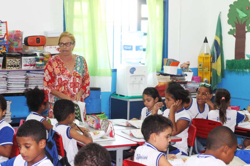 Imagem de professora em pé em sala de aula