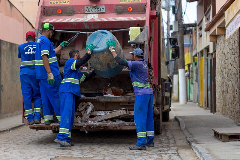 Foto de homens trabalhando na coleta de lixo
