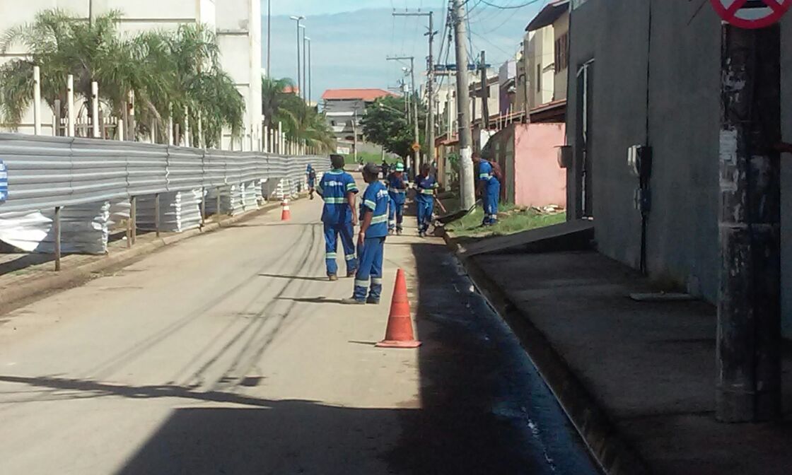 Foto de funcionários da prefeitura fazendo limpeza em rua.