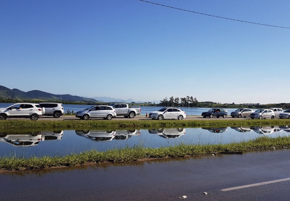 carros enfileirados e muita água ao redor