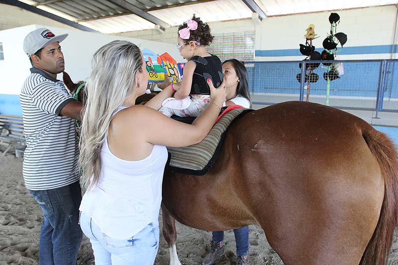 Foto de criança montada num cavalo