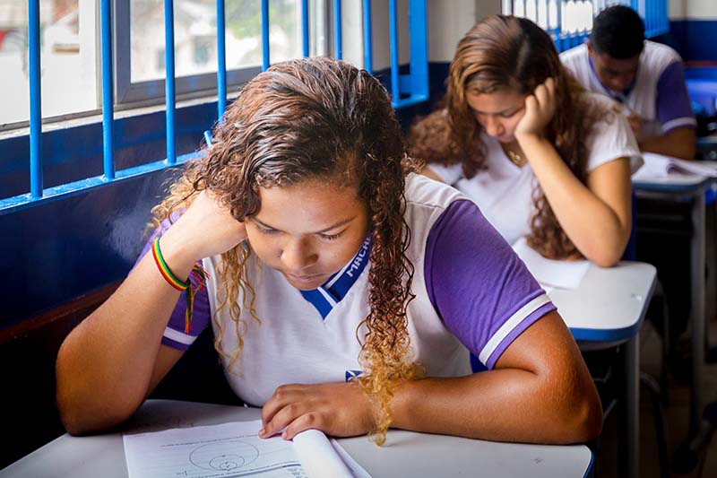 Foto de alunos uniformizados em sala de aula