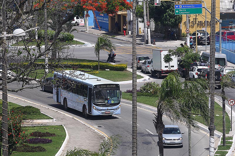 Foto de ônibus e carros circulando via pública