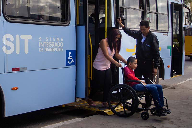 Foto de cadeirante descendo do ônibus em cadeira de rodas