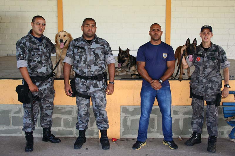 Foto de quatro agentes e três cachorros