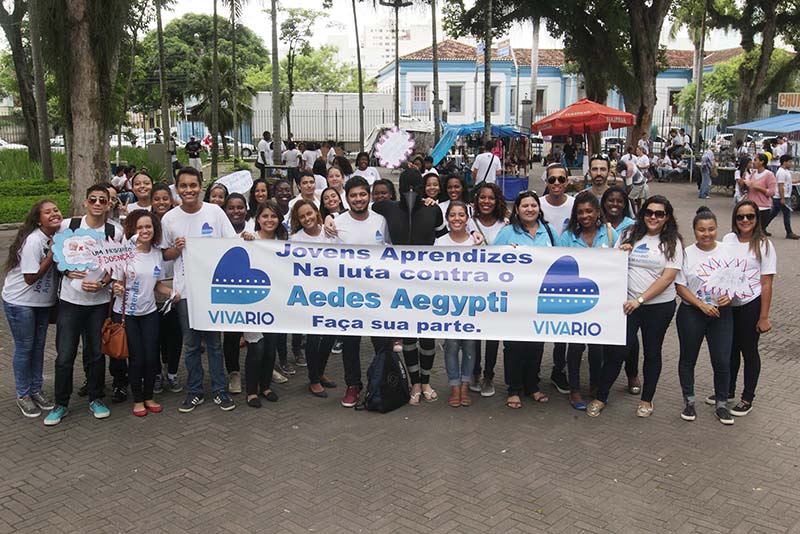 Foto dos jovens aprendizes na praça com faixa